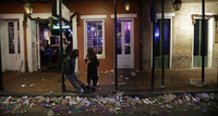 Trash lines the gutter on Bourbon Street, in the early hours of the morning after Mardi Gras, in New Orleans, Feb. 18, 2015. It's a beloved century-old Carnival season tradition in New Orleans — masked riders on lavish floats fling strings of colorful beads or other trinkets to parade watchers clamoring with outstretched arms.