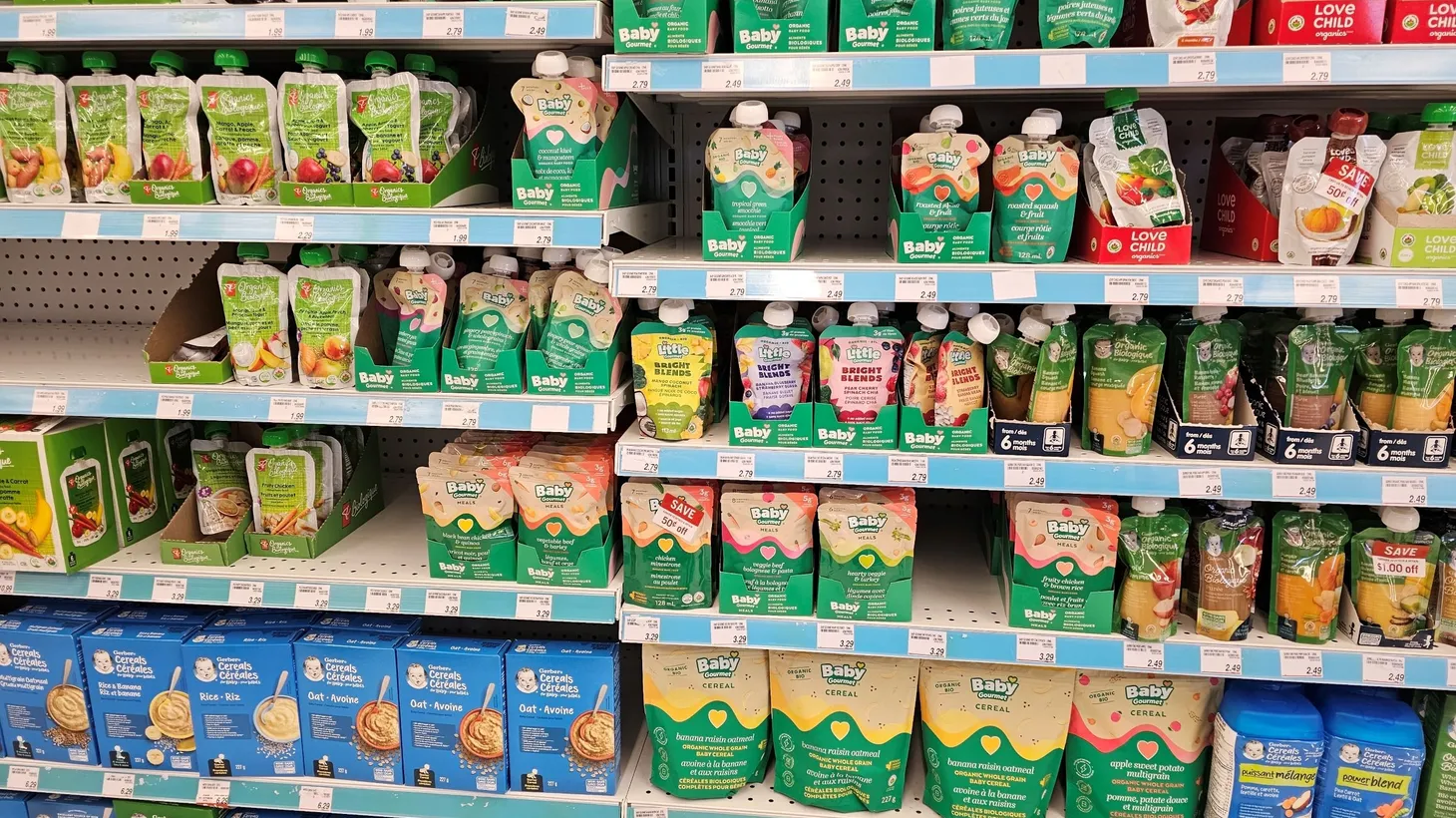 The baby food aisle of the grocery store is stocked with applesauce pouches.
